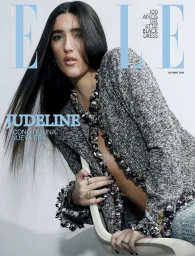 Judeline posing for Elle Mexico October 2026 cover wearing a textured tweed jacket and seated on a chair against a plain white backdrop