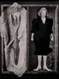 Gwendoline Christie wearing a black dress inside a wooden compartment beside a large decorative fish fork resting on lace fabric
