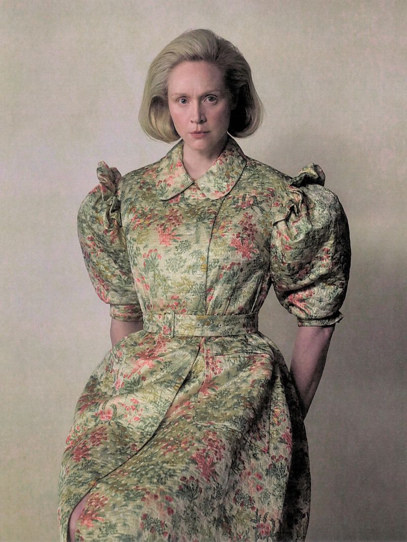 Gwendoline Christie wearing a patterned floral dress with puffed shoulders against a neutral textured background