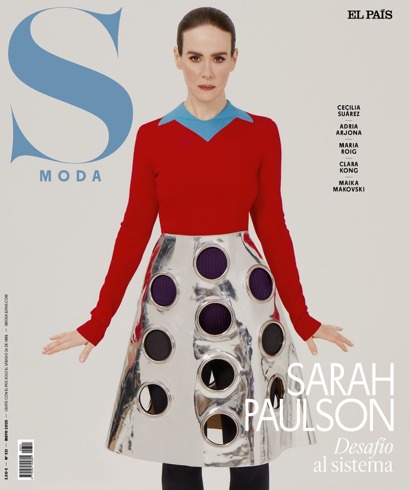 Fashion editorial image featuring Sarah Paulson in a red top and a metallic skirt with circular cutouts, posing against a neutral backdrop.