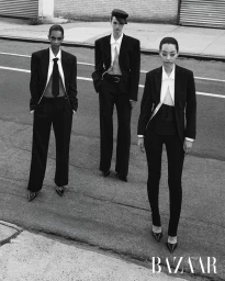 Three models wearing tailored black suits and white shirts posing on an asphalt street for Harper's Bazaar Thailand