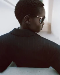 Model Ateta Jok wearing sunglasses and a black pinstripe blazer in a Puss Puss Magazine editorial.
