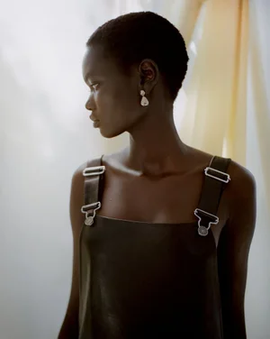 Model Ateta Jok wearing a dark leather dress with silver hardware in a fashion editorial for Puss Puss Magazine by Maya Skelton.