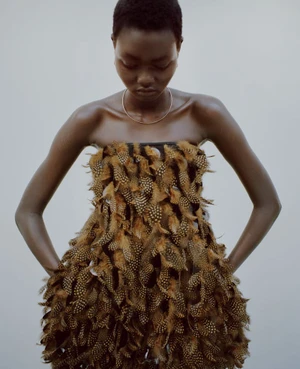 Model Ateta Jok wearing a textured brown feather strapless dress in Puss Puss Magazine editorial Silver Rain