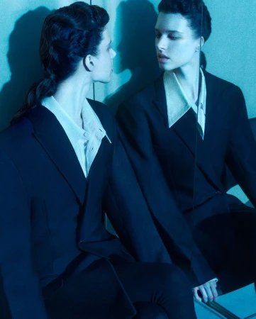 Model reflected in a mirror wearing a dark blazer and collared shirt under cool blue lighting for Financial Times HTSI Magazine