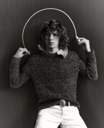 Monochrome portrait of Paul Kircher holding a chalk line above his head against a dark background for ICON Magazine France.