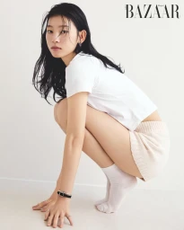 Model Sol Jeong squatting in a white t-shirt and white shorts against a seamless white studio background for Harper's Bazaar Korea