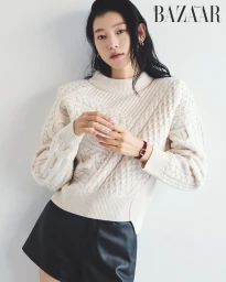 Model Sol Jeong in a cream cable knit sweater and black shorts for a Harper's Bazaar Korea editorial against a white seamless background