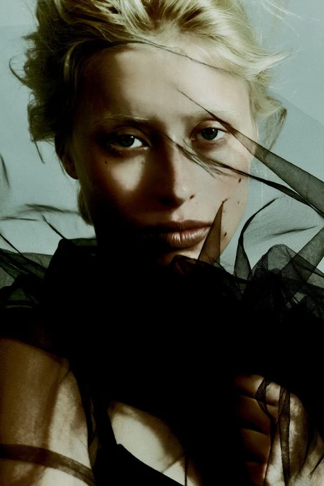 Close-up portrait of a blonde woman wearing a black sheer veil across her face for Vogue Portugal by Polina and Vladimir Mordvinovs
