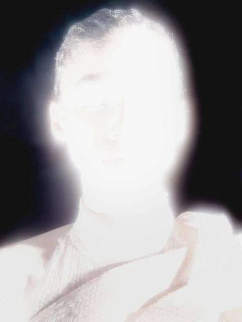 High-key portrait of an adult with a bright overexposed lighting creating a glowing effect, shot with a shallow depth of field.