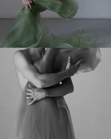Monochromatic studio shot of person draped with sheer fabric, artfully obscuring form and focusing on texture and light.