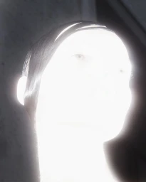 Overexposed, high-contrast close-up portrait of a person with glowing white facial contours and sleek dark hair against a dark backdrop.