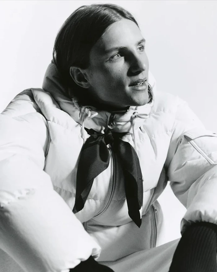 Model Indiana Van't Slot wearing a white puffer jacket and dark neck scarf against a white background