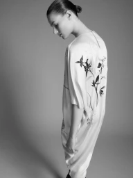Model Famke van Hasselt in a white patterned tunic dress against a neutral grey studio background by photographer Domenico Petralia.