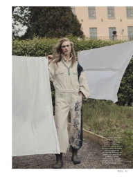 Model Hedvig Palm wearing a utility jumpsuit outdoors amidst white laundry sheets for Telva magazine