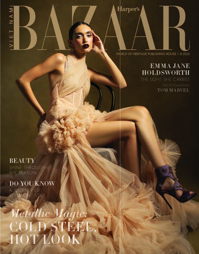 Fashion magazine cover featuring a posed female model wearing a formal peach-colored dress and purple high heels in a photo studio.