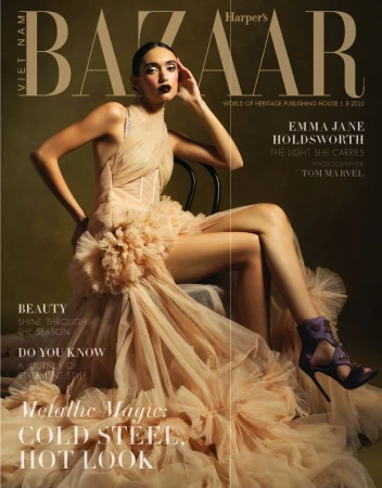 Fashion magazine cover featuring a posed female model wearing a formal peach-colored dress and purple high heels in a photo studio.