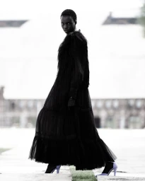 Model Hakim Deng poses outdoors in a voluminous tiered black tulle gown and lavender heels for Numero Netherlands Westerpark editorial.