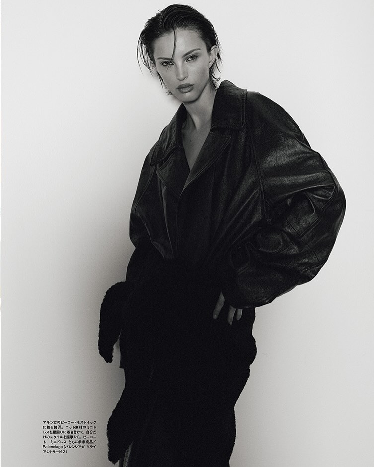 Model in oversized black leather jacket and dark coat against a plain white background for Numero Tokyo Lulu Wood editorial.
