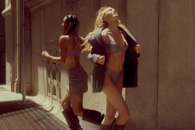 Two models wearing bras and underwear outdoors against a building exterior wall during the Victoria's Secret FlexFactor campaign