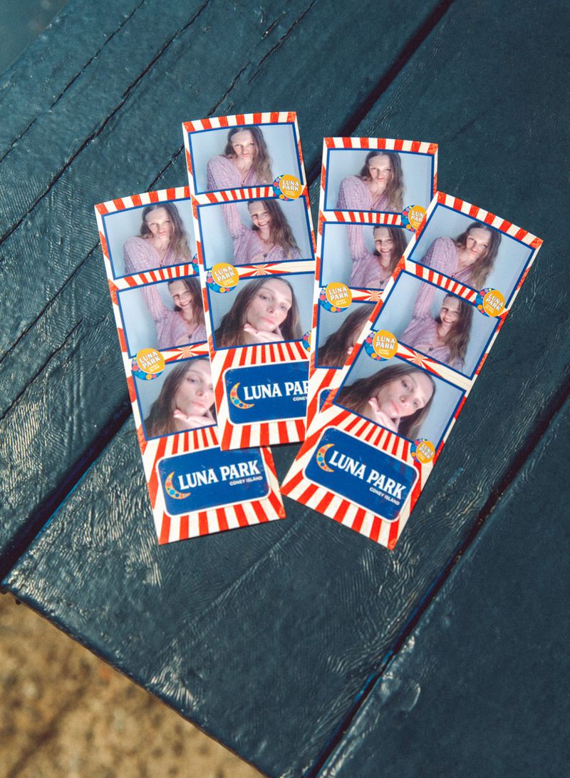 Photo booth strips featuring a young adult with long hair, posing in multiple frames, on a dark wooden surface with Luna Park logo.