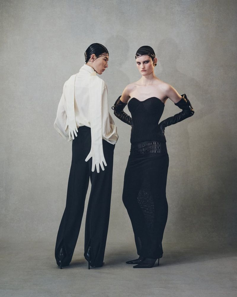 Two fashion models showcase elegant black and white attire against a neutral background, highlighting textures, and unique glove details.