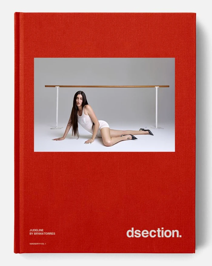 Judeline reclining on a white floor in front of a ballet barre for DSECTION Magazine editorial photography by Bryan Torres.