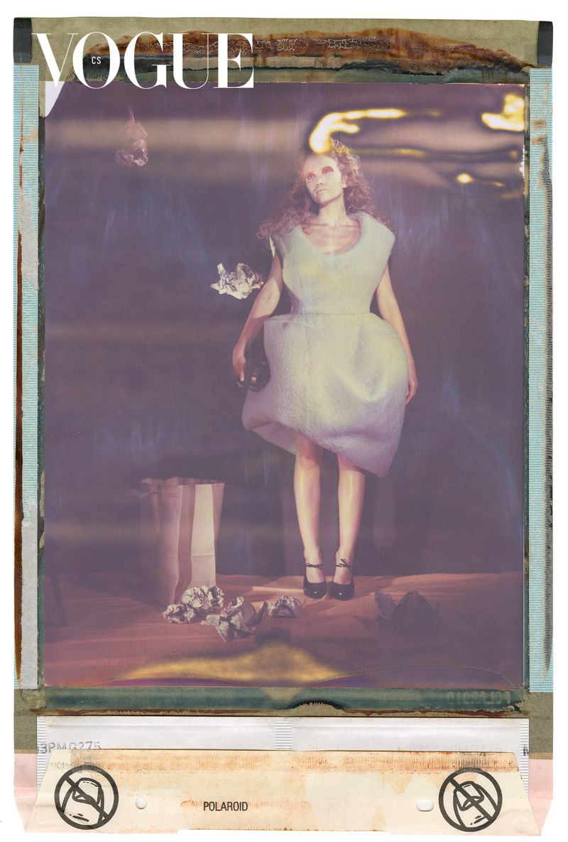Fashion editorial shot for Vogue CS features a woman in a white dress, posed in an indoor studio with a blurred background.