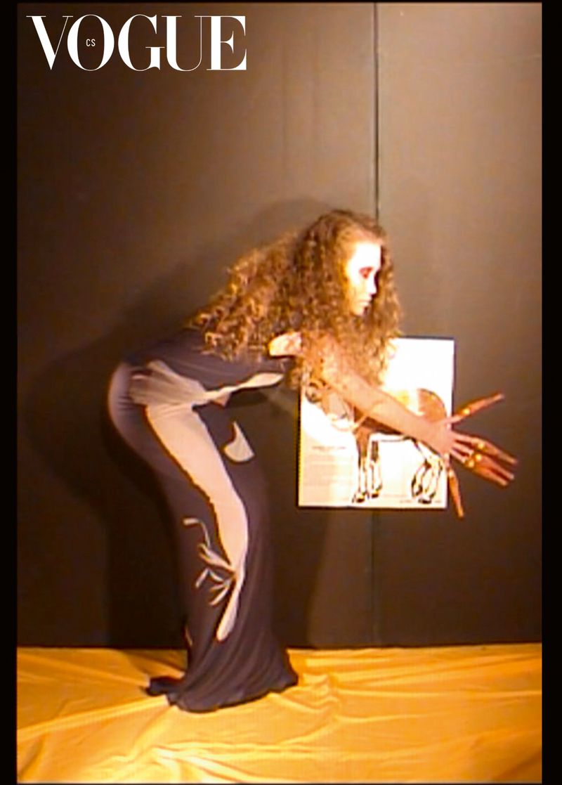 A woman in a dress with a poster in front of a dark background, in a fashion-editorial style, Vogue logo visible.