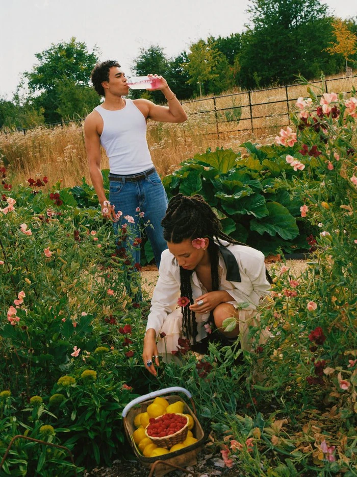 Man drinking from a bottle and woman kneeling in a garden with a basket of lemons and raspberries for the Humantra RL Launch Campaign