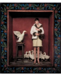 Actor Emma Corrin standing inside a dark red box surrounded by white ducks for Harper's Bazaar UK photographed by Szilveszter Mako