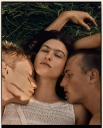 Three models lying together in tall grass with close-up framing, photographed by Claire Harrison for Rakes Progress.