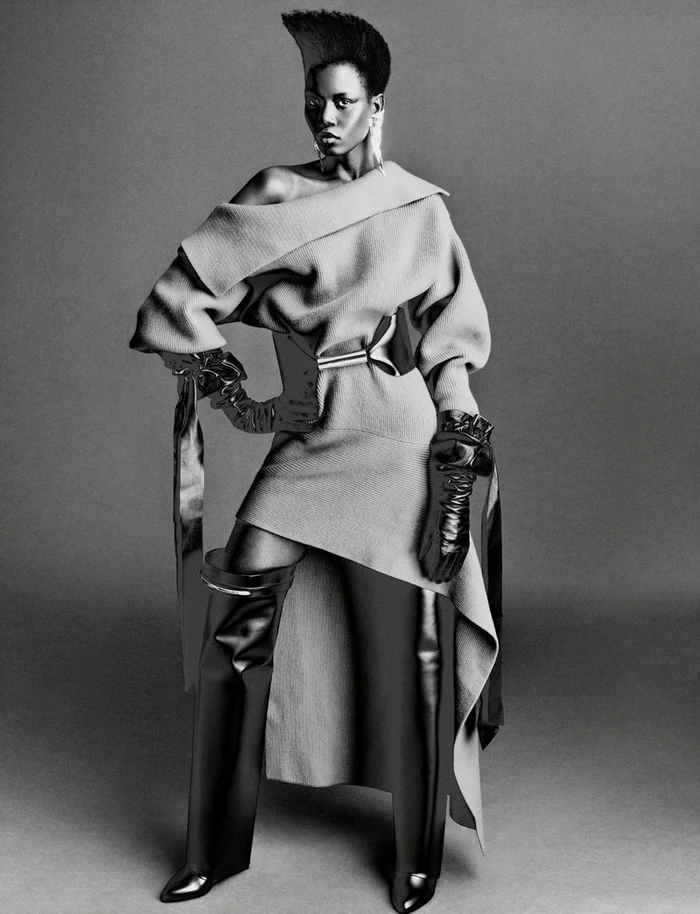 Model Ajah Angau Jok in architectural draped dress with tall leather boots for French Magazine editorial