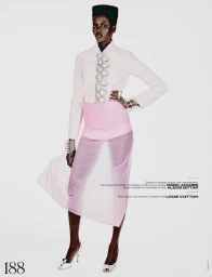 Model wearing pale pink jacket and sheer pink skirt against a plain white studio background.