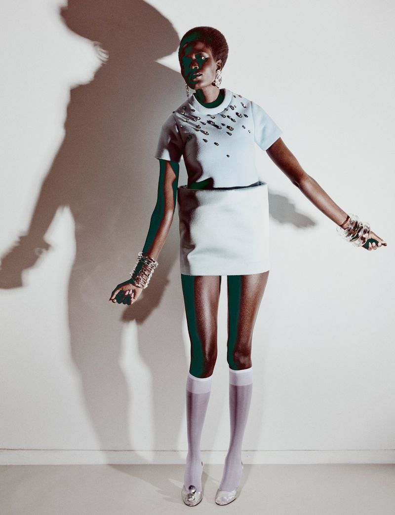 Model Ajah Angau Jok wearing a light blue structured dress and knee-high white socks against a plain white studio backdrop.