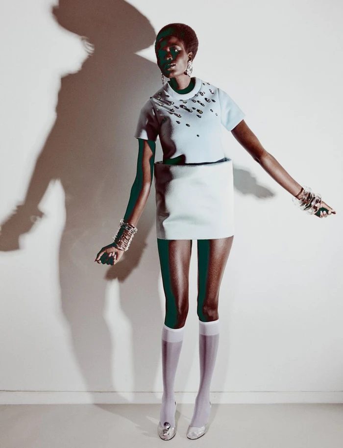 Model Ajah Angau Jok wearing a light blue structured dress and knee-high white socks against a plain white studio backdrop.