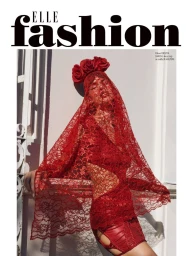 Model in red lace veil and red roses headdress leaning against an exterior wall for Elle Bulgaria editorial