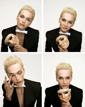 Four-panel grid showing model Alex Consani in a black tuxedo jacket with a white bowtie, holding and interacting with a theatrical mask.