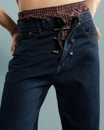 Close up of model wearing unbuttoned dark denim jeans revealing plaid boxers for Fucking Young Performing Masculinities