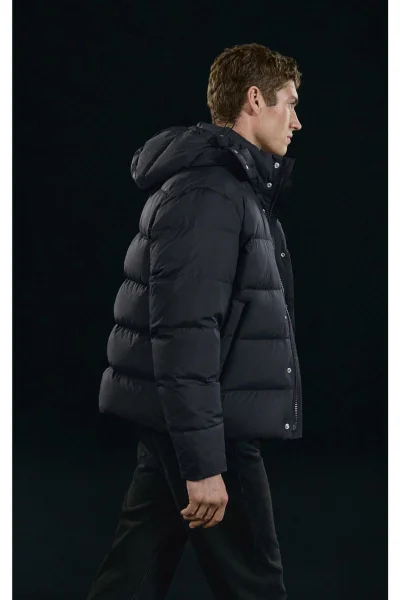 Valentin Humbroich wearing a black puffer jacket against a dark background for Massimo Dutti