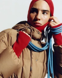 Model in red balaclava and brown puffer jacket holding blue rope for Moncler Spring 2027