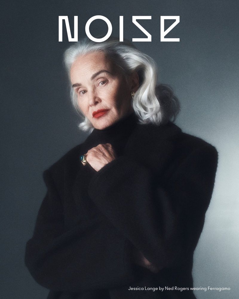 Portrait of Jessica Lange with white hair wearing a black coat against a grey gradient background for Beyond Noise Issue 6.