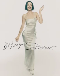 Model Julia Fox in a satin slip dress posing against a white seamless background for the Betsey Johnson holiday campaign