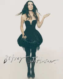 Julia Fox in a black strapless bubble dress and patterned tights against a white seamless background for Betsey Johnson Holiday 2026