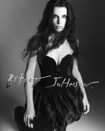 Julia Fox in a black strapless dress for the Betsey Johnson holiday campaign against a grey seamless background