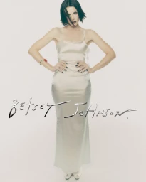 Julia Fox wearing a light-coloured satin slip dress against a clean white background for Betsey Johnson Holiday 2026