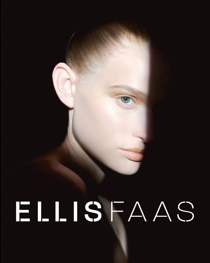 Close-up portrait of a woman with slicked-back hair in dramatic low-key lighting against a dark background with white brand text.