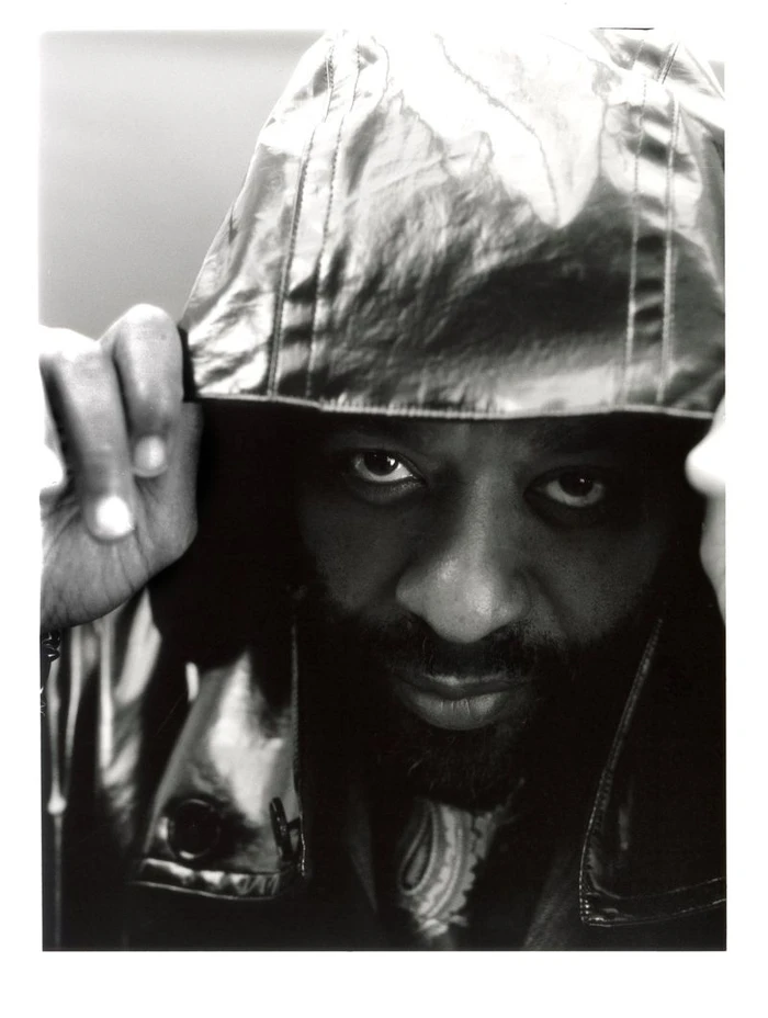 Portrait of Chiwetel Ejiofor pulling up a glossy hooded jacket for The Shapeshifter project in Esquire UK.