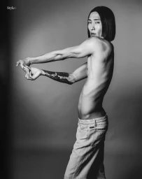 Model Hyuk Kim stretching his arms in a studio portrait for The Perfect Man Magazine, photographed by Ferran Casanova.