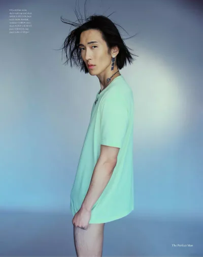 Model Hyuk Kim wearing a mint green t-shirt against a soft gradient blue studio background for The Perfect Man Magazine.